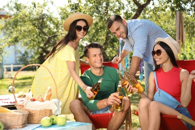 Photo of Young people enjoying picnic in park on summer day