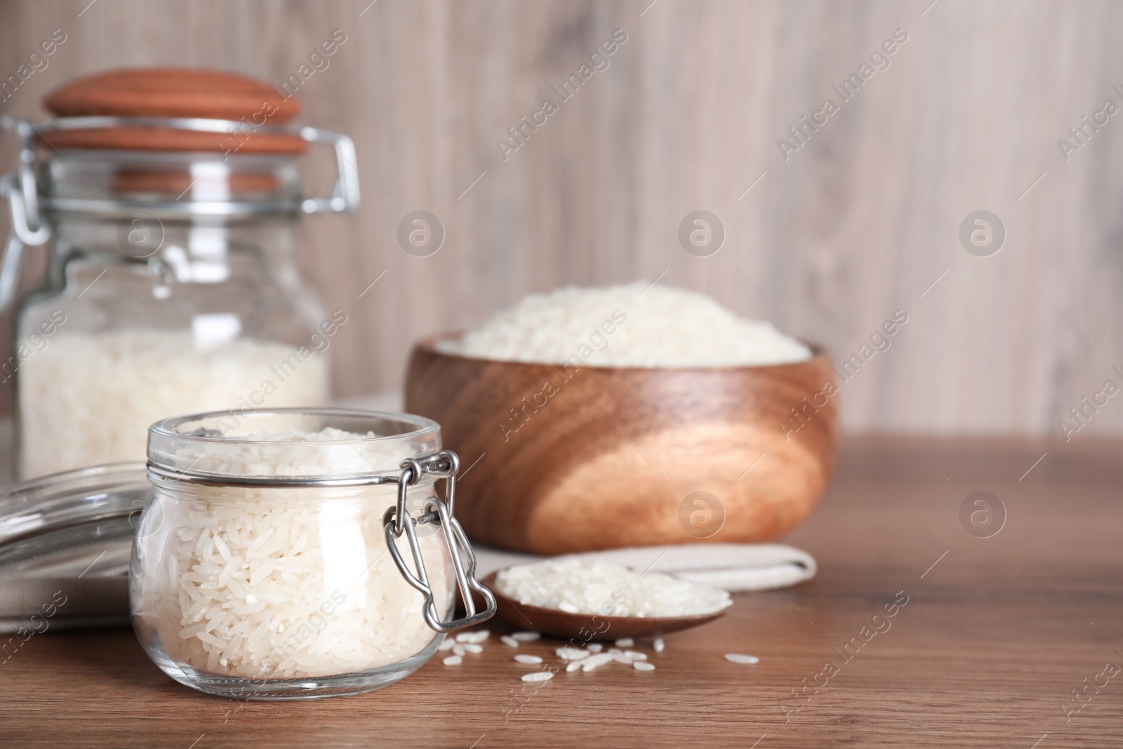 Photo of Uncooked rice on wooden table, space for text