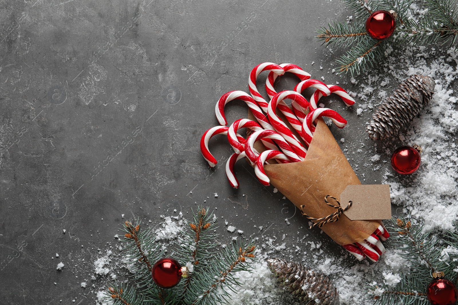 Photo of Flat lay composition with candy canes and Christmas decor on grey background