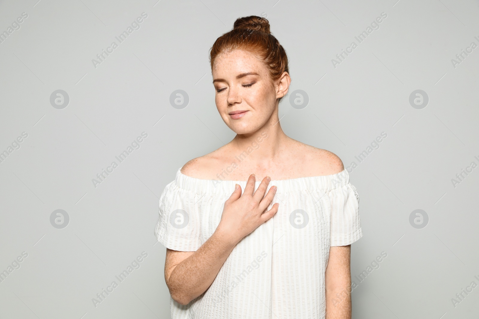 Photo of Portrait of young woman with beautiful face on grey background