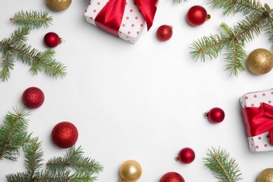 Composition with Christmas tree branches, festive decor and gift boxes on white background