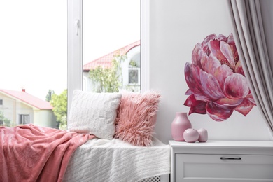 Photo of Soft pillows and plaids on window sill in room. Cozy place to relax