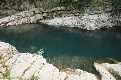 Photo of Beautiful clean pond between big cliffs outdoors