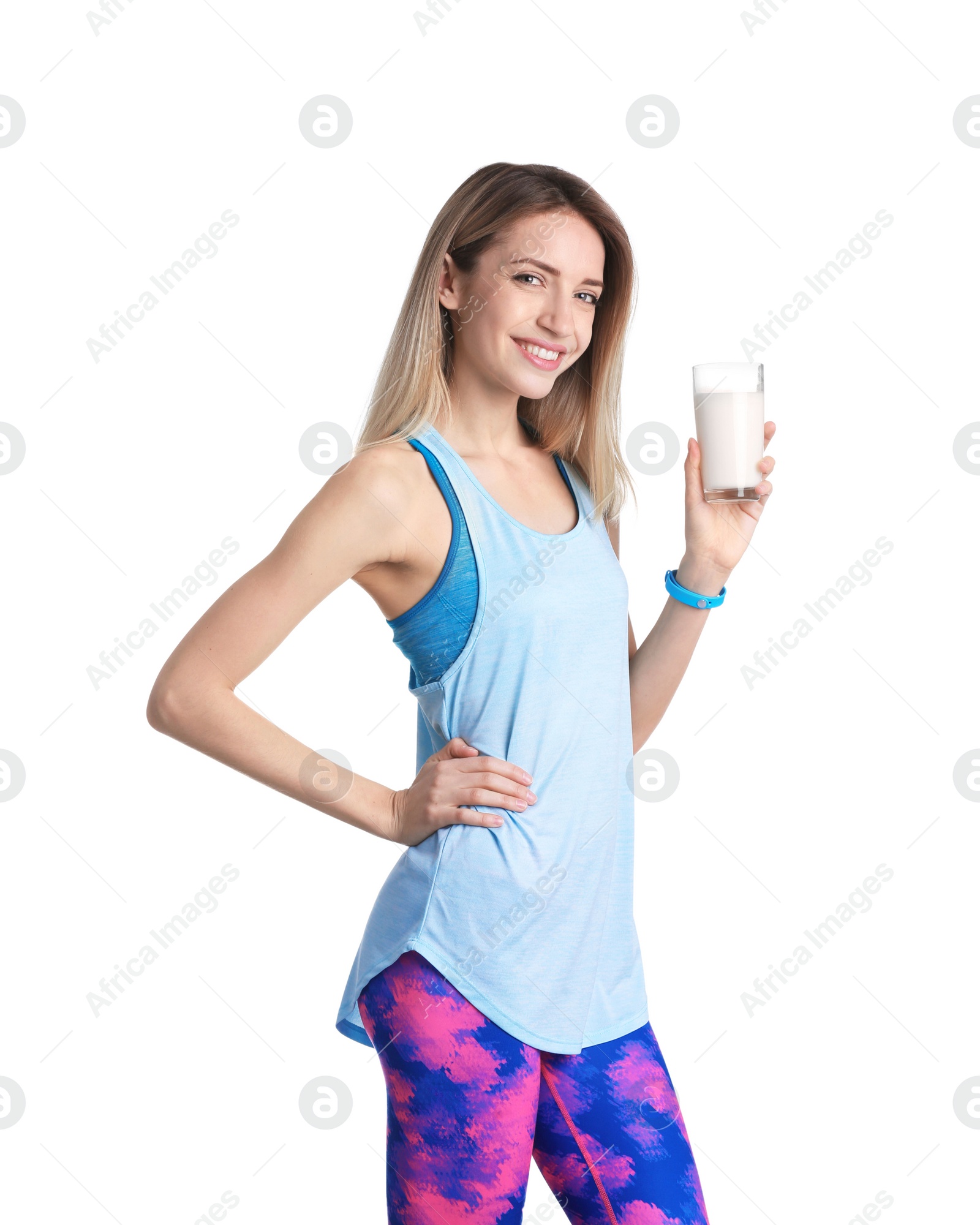 Photo of Beautiful young woman in sportswear drinking milk on white background