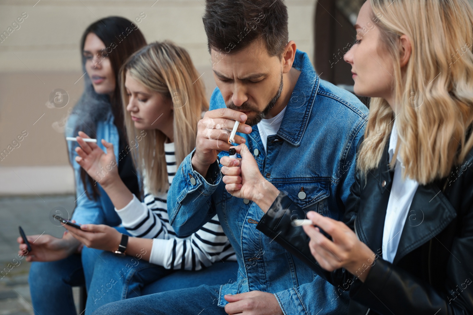 Photo of People smoking cigarettes at public place outdoors