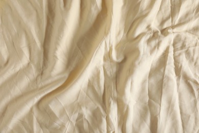 Crumpled beige fabric as background, top view