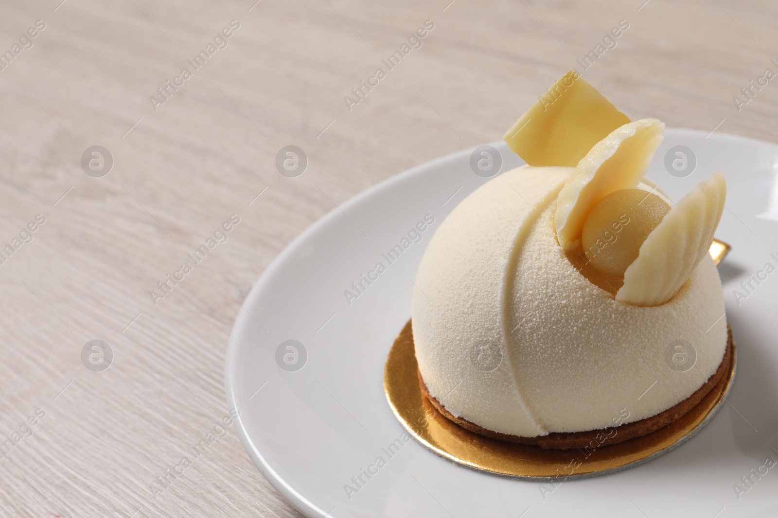 Photo of Delicious mousse cake with white chocolate on wooden table, closeup. Space for text