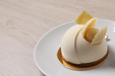 Delicious mousse cake with white chocolate on wooden table, closeup. Space for text