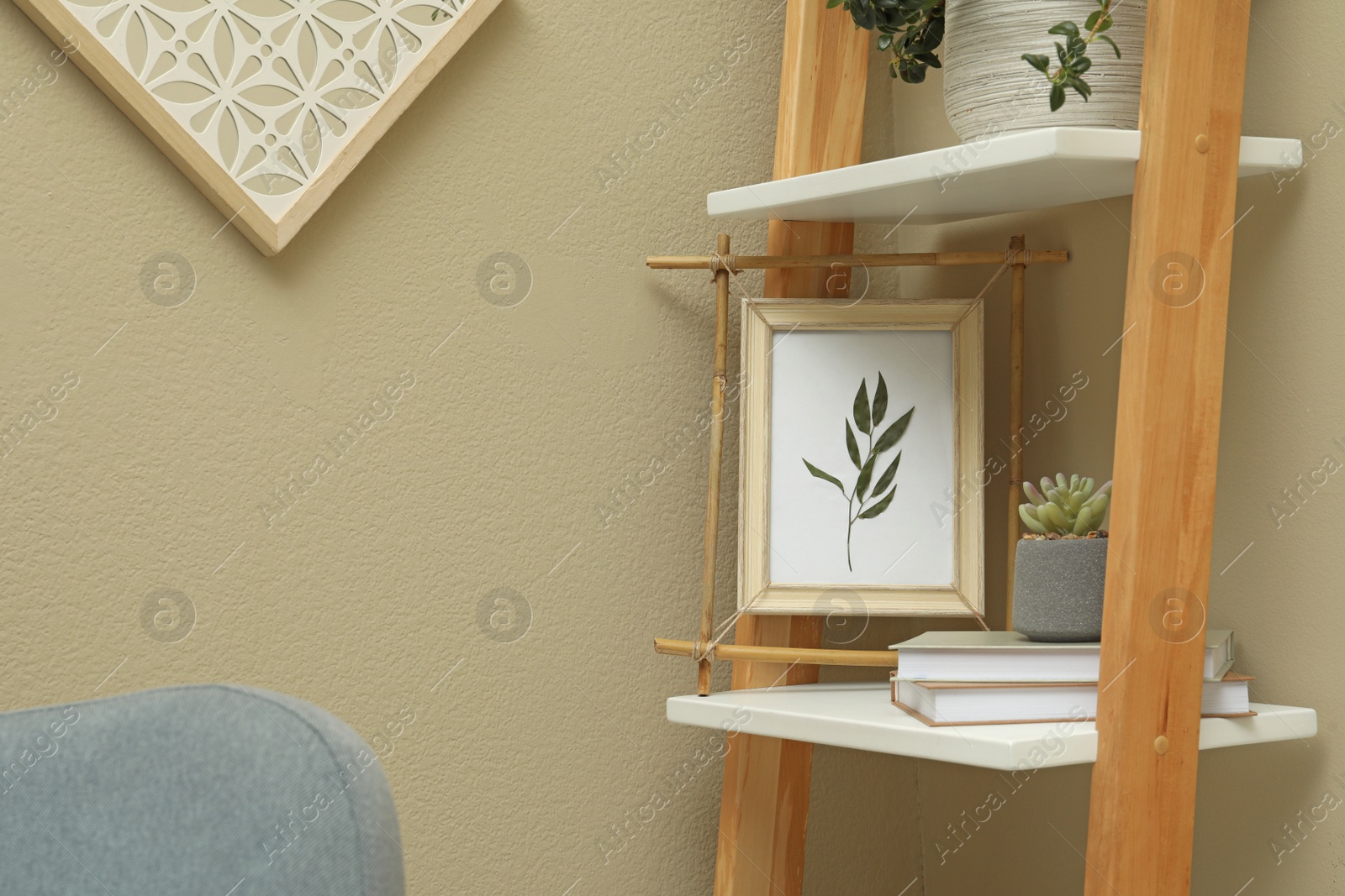 Photo of Bamboo frame and different decor elements on shelving unit indoors