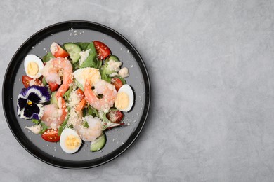 Photo of Delicious Caesar salad with shrimps on grey table, top view. Space for text