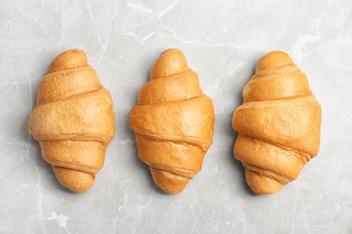 Photo of Tasty croissants on light background, top view