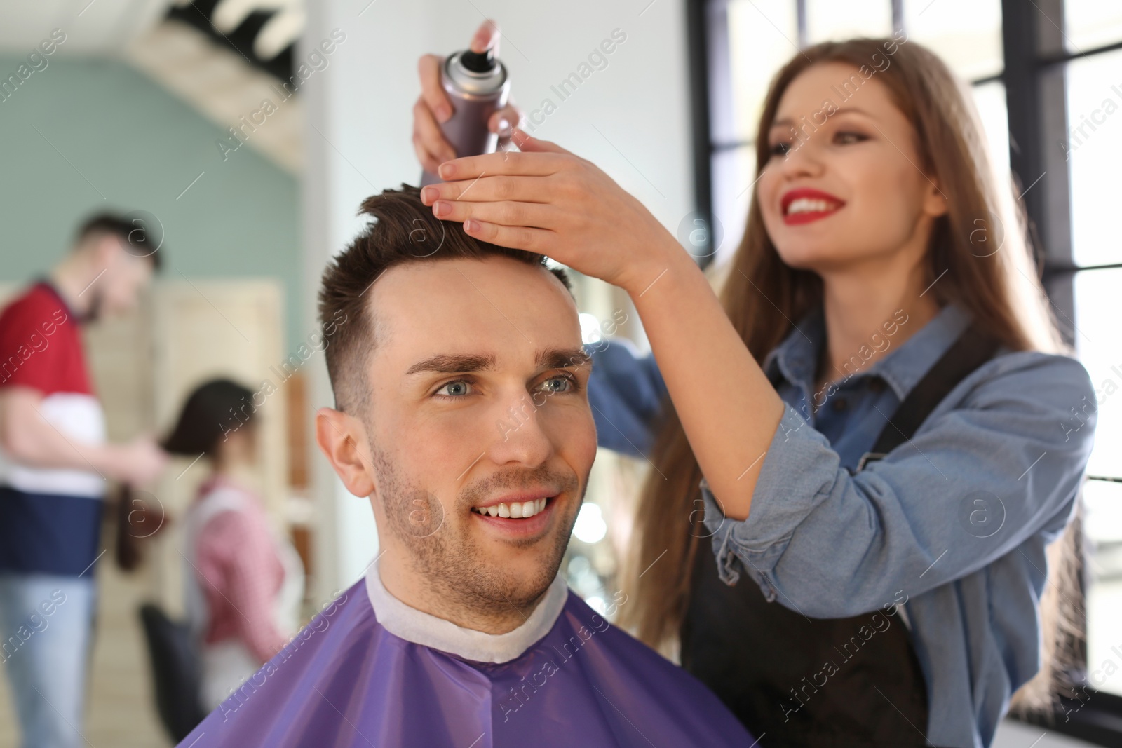 Photo of Professional hairdresser working with client in beauty salon