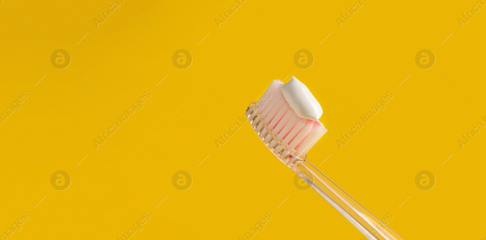 Image of Brush with toothpaste on yellow background, space for text. Banner design