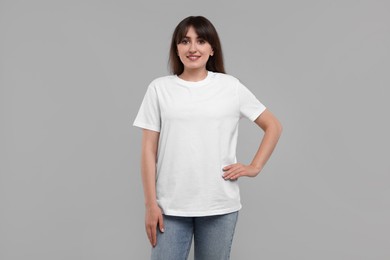 Photo of Smiling woman in white t-shirt on grey background