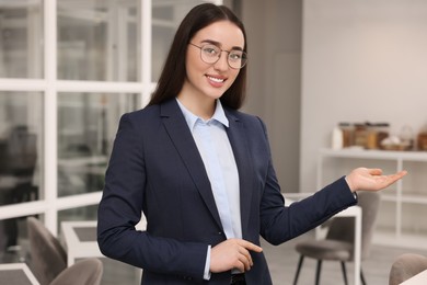 Happy female real estate agent in office