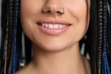 Photo of Young woman with nose piercing and dreadlocks, closeup