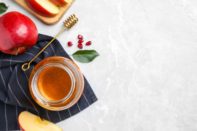 Photo of Honey, apples and pomegranate seeds on light grey marble table, flat lay with space for text. Rosh Hashanah holiday