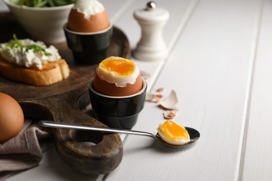 Photo of Breakfast with soft boiled egg served on white wooden table. Space for text