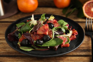 Photo of Delicious salad with sicilian orange on wooden table, closeup