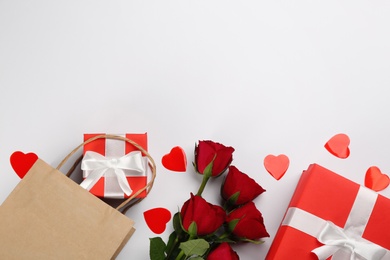 Photo of Gift boxes, roses and hearts on white background, flat lay with space for text. Valentine's Day celebration