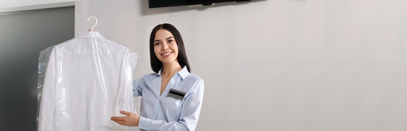 Image of Female worker with clean shirt, banner design. Dry-cleaning service