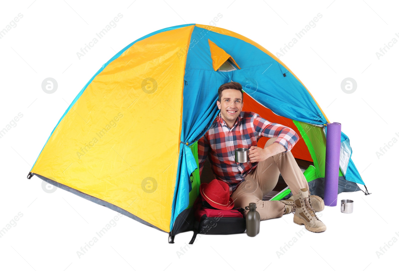 Photo of Young handsome man sitting in tourist tent on white background