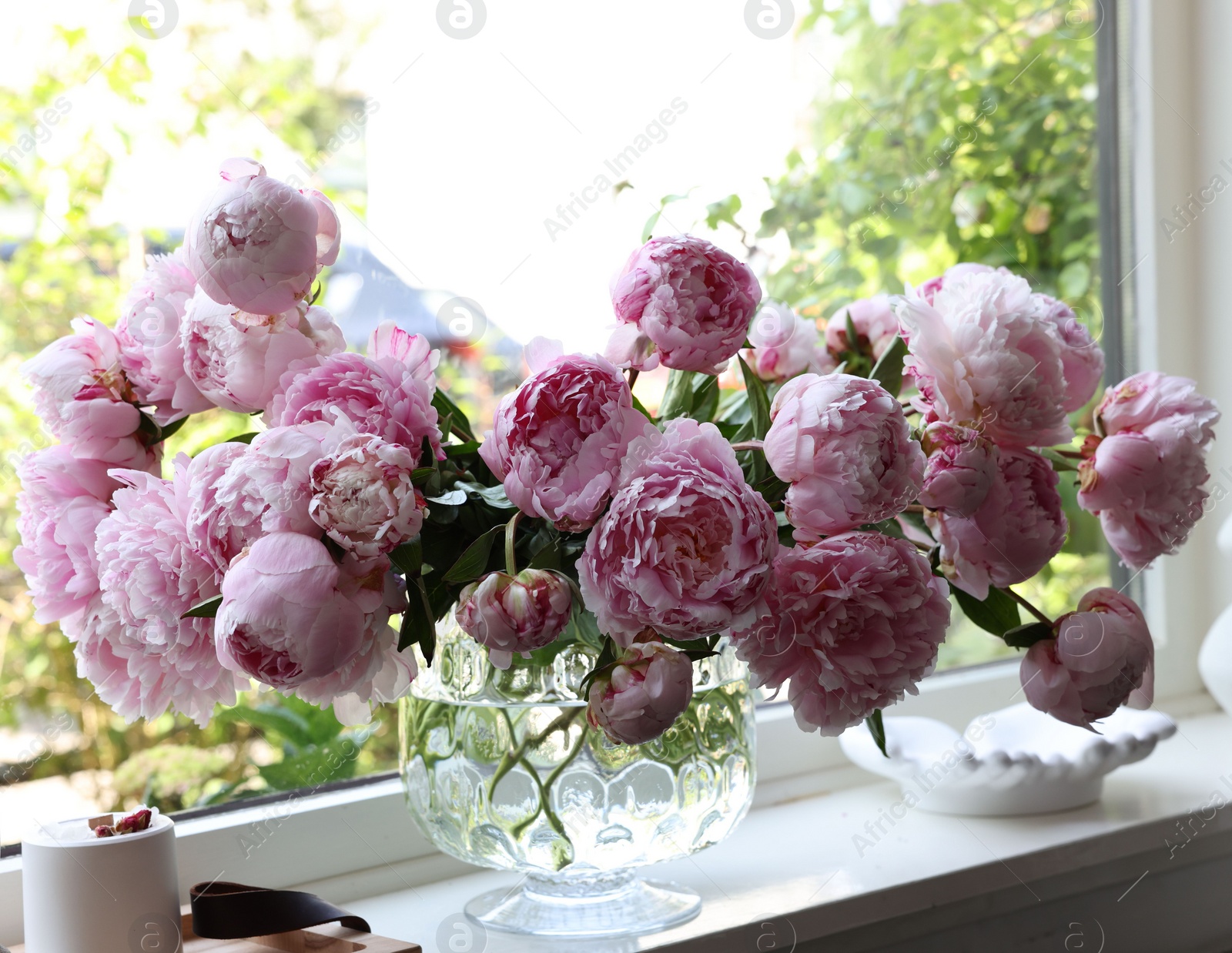 Photo of Beautiful pink peonies in vase on window sill. Interior design