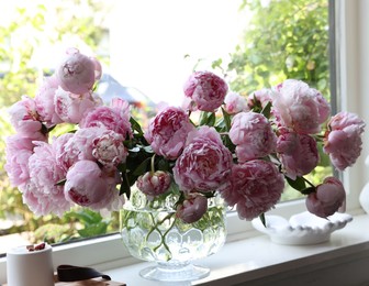 Photo of Beautiful pink peonies in vase on window sill. Interior design