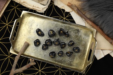Many black rune stones on divination mat, flat lay