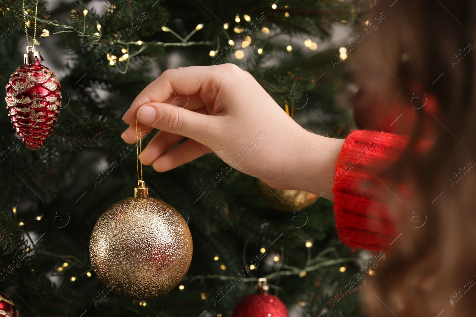 Photo of Woman decorating Christmas tree with beautiful bauble, closeup