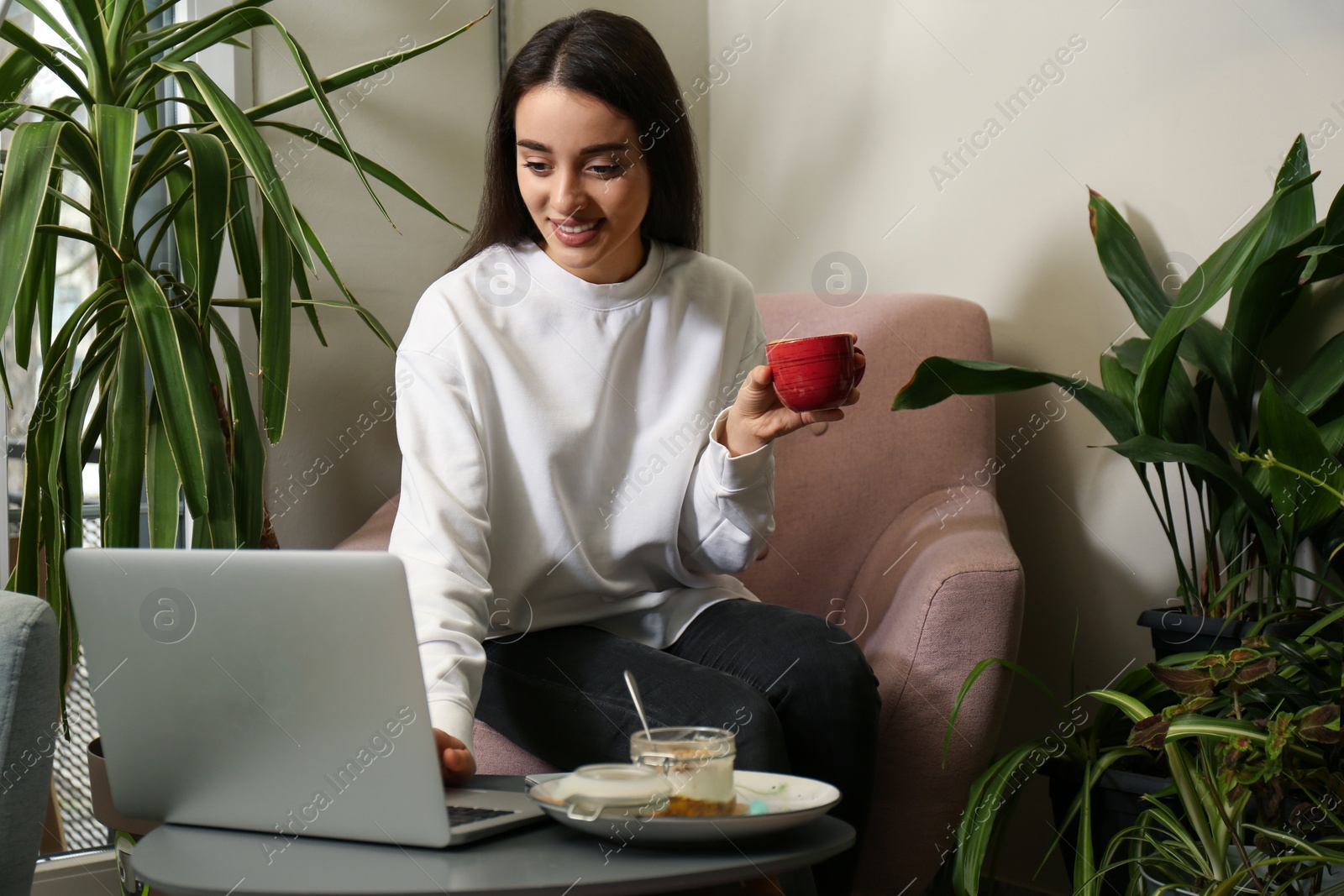 Photo of Young blogger working with laptop in office