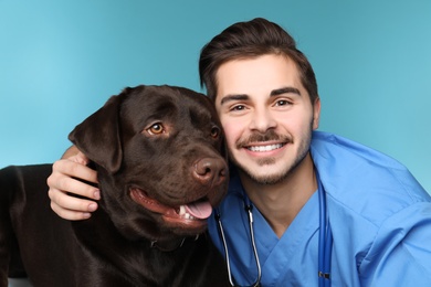 Photo of Veterinarian doc with dog on color background