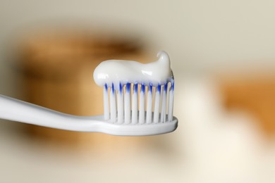 Plastic toothbrush with paste on blurred background, closeup