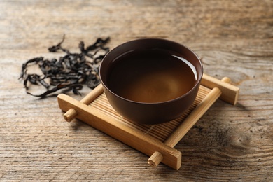 Photo of Cup of Da Hong Pao oolong and tea leaves on table