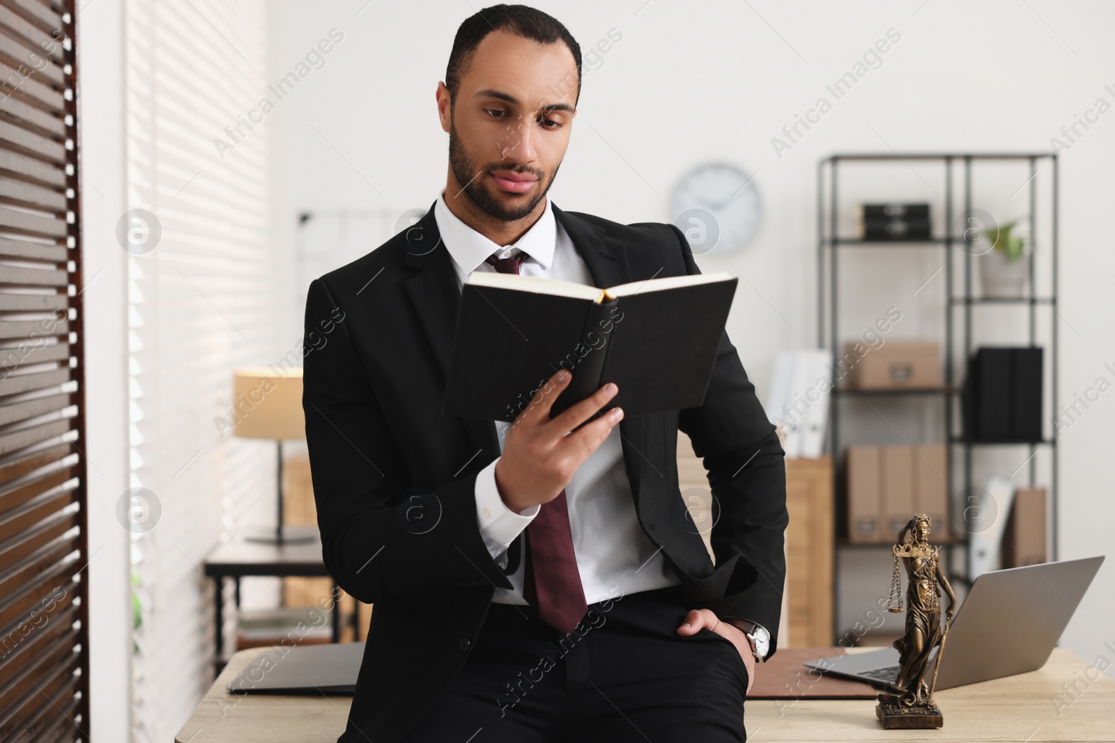 Photo of Portrait of serious lawyer with book in office