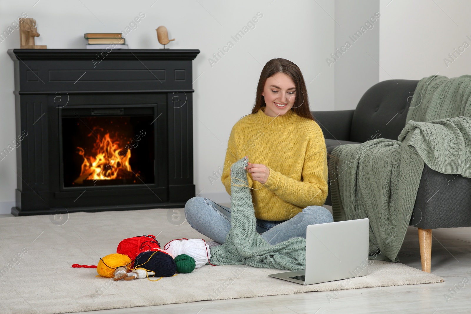 Photo of Young woman learning to knit with online course at home, space for text. Handicraft hobby