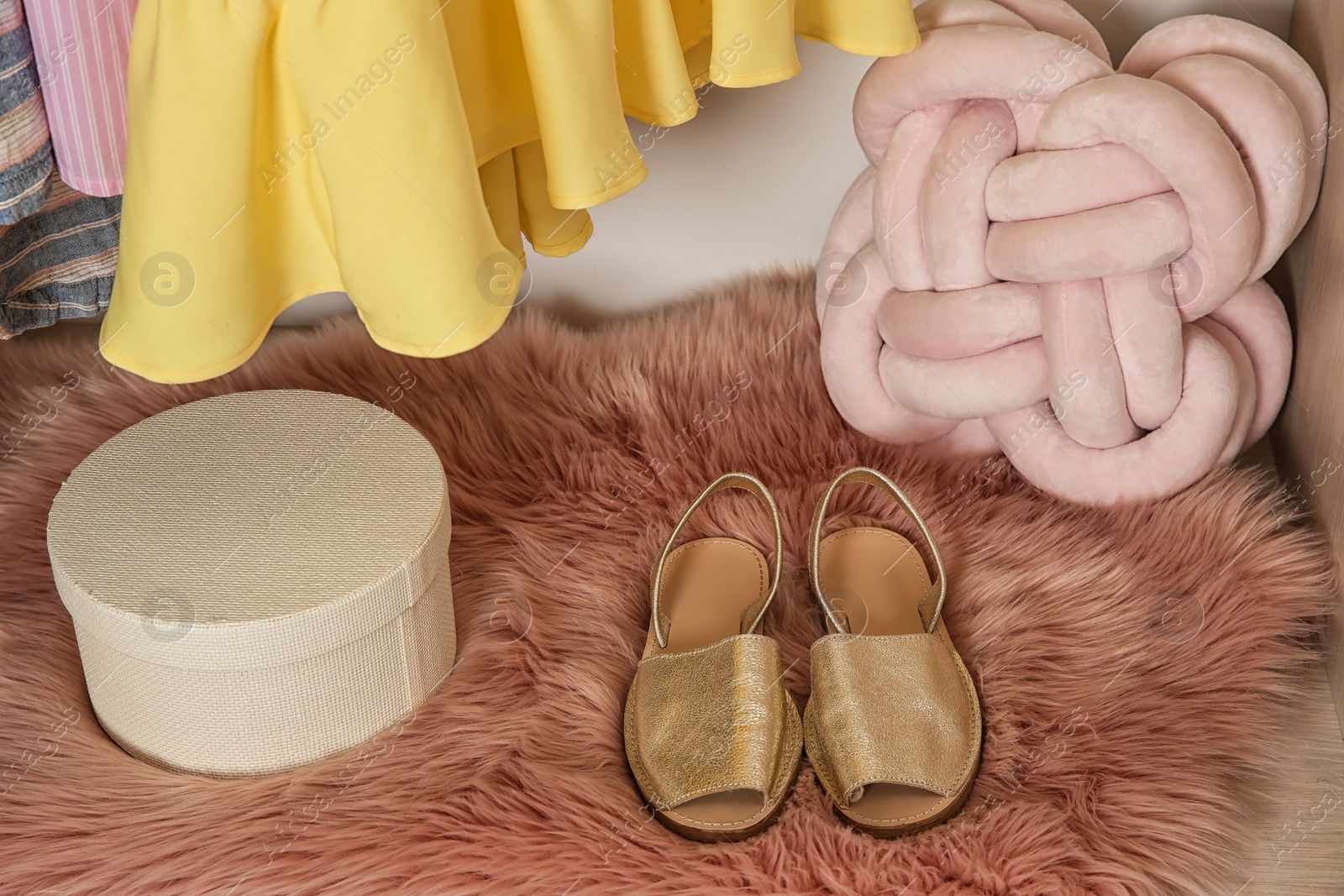 Photo of Golden shoes for girl on fur rug. Stylish wardrobe