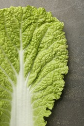 Photo of Fresh Chinese cabbage leaf on gray textured table, top view