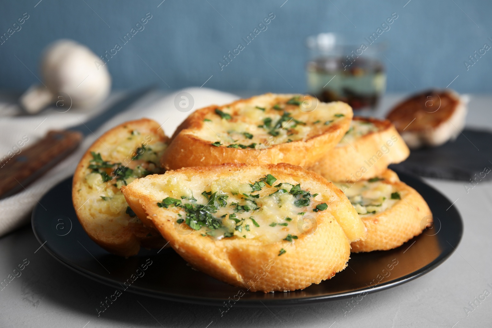 Photo of Plate with delicious homemade garlic bread on table