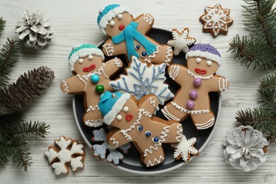 Photo of Delicious Christmas cookies, pine cones and fir branches on white wooden table, flat lay