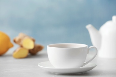 Photo of Tea with lemon in cup on table against color background