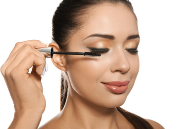 Photo of Beautiful woman applying mascara on white background. Stylish makeup