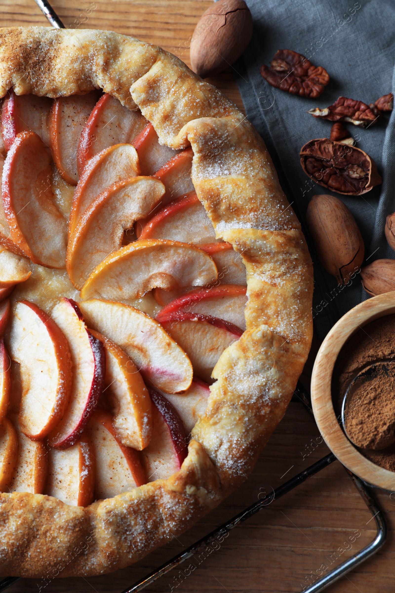 Photo of Delicious apple galette, cinnamon and pecans on table, flat lay