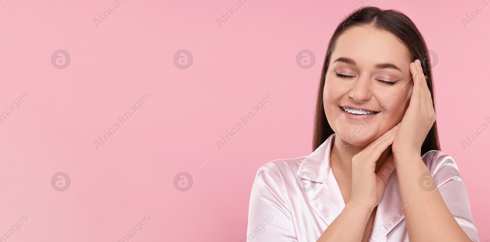 Image of Smiling woman with braces on pink background. Banner design with space for text