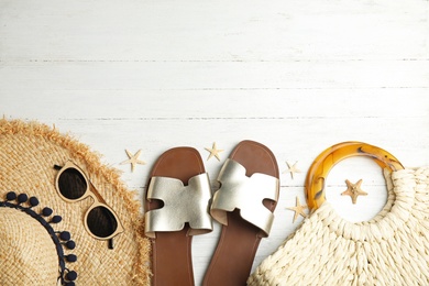 Flat lay composition with beach objects on white wooden background. Space for text