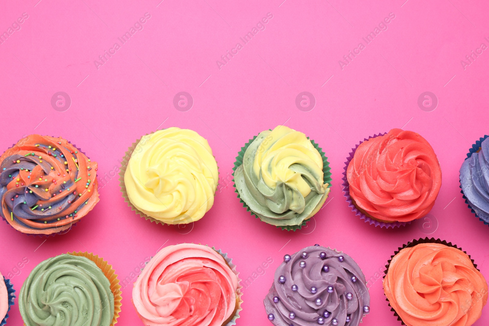 Photo of Delicious cupcake with bright cream on pink background, flat lay