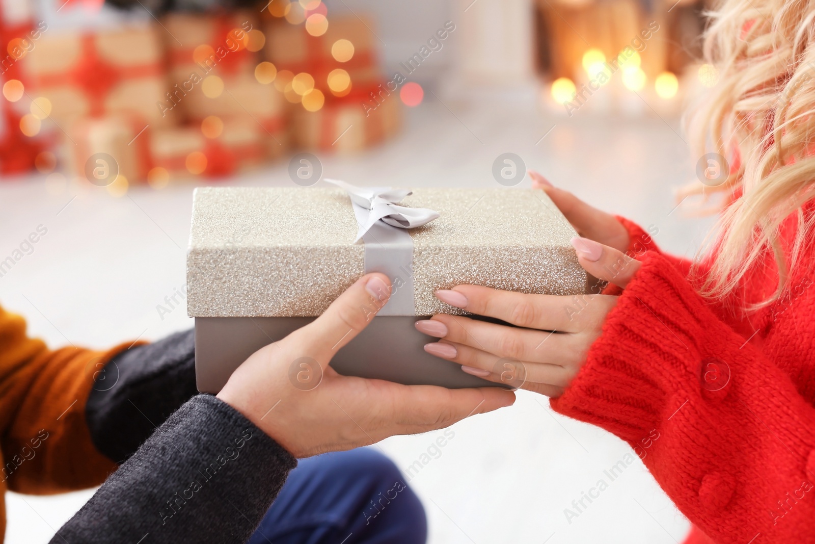 Photo of Young couple with Christmas gift at home