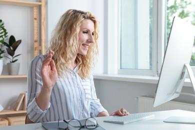 Photo of Beautiful young woman using video chat at desk in office