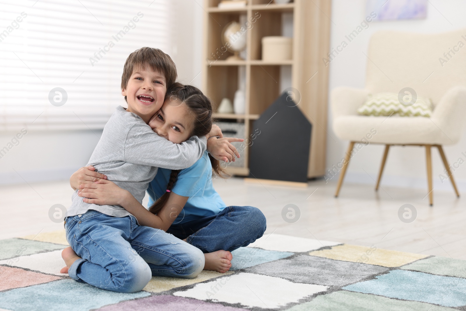 Photo of Happy brother and sister hugging together at home, space for text