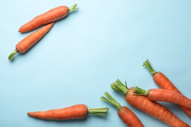 Photo of Flat lay composition with fresh carrots on color background. Space for text